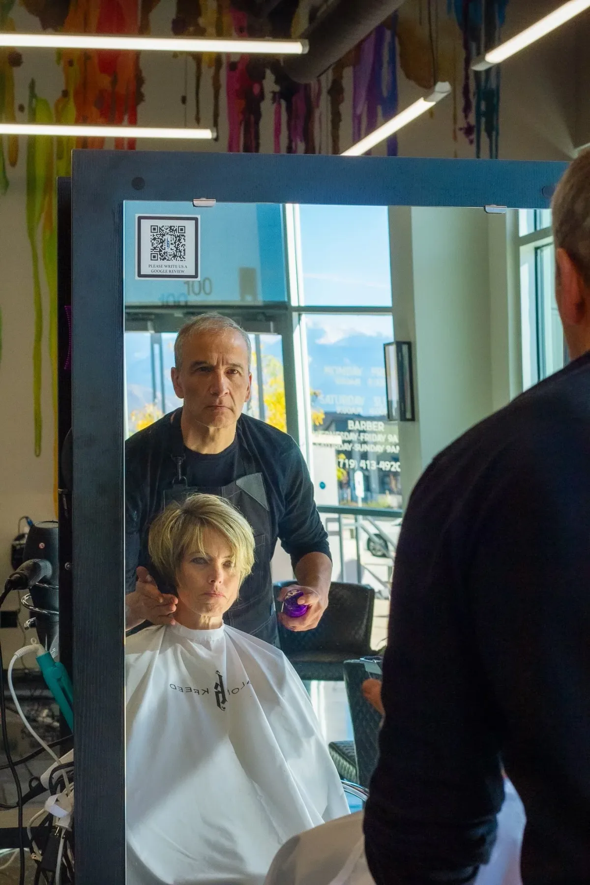 A guest getting her hair cut at Salon Kreed